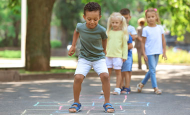 Little Children Playing Hopscotch